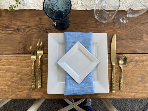 White square china with hammered gold flatware
